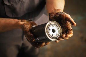 Auto mechanic with dirty hands and oil filter.