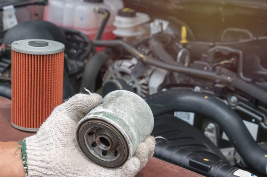 Mechanic holding worn-out oil filter