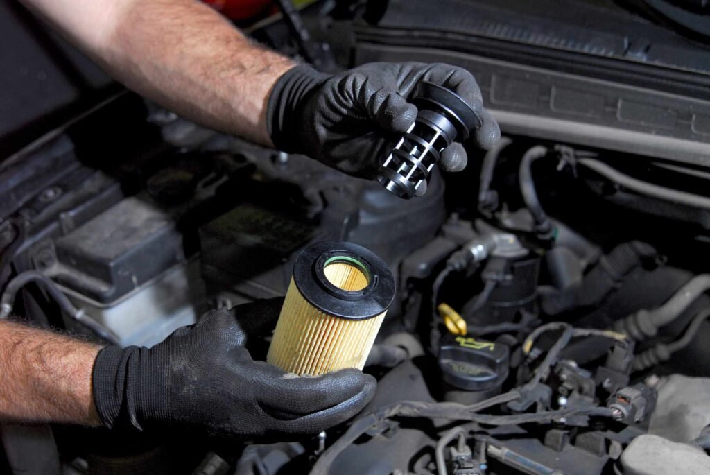 Mechanic's hand holding new oil filter